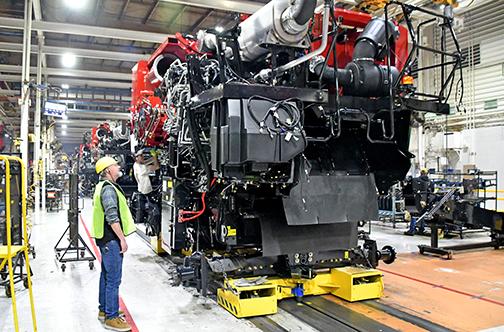 Marquette area corn grower Cale Carlson inspects a nearly complete combine at one of the stations along the assembly line at the Case IH plant in Grand Island Friday morning. 