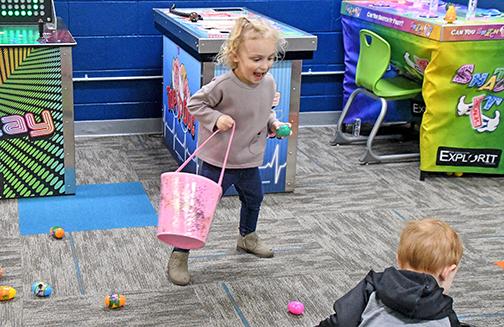 Aspyn Knapp runs into the Discover-It Zone to collect as many eggs as she can. 