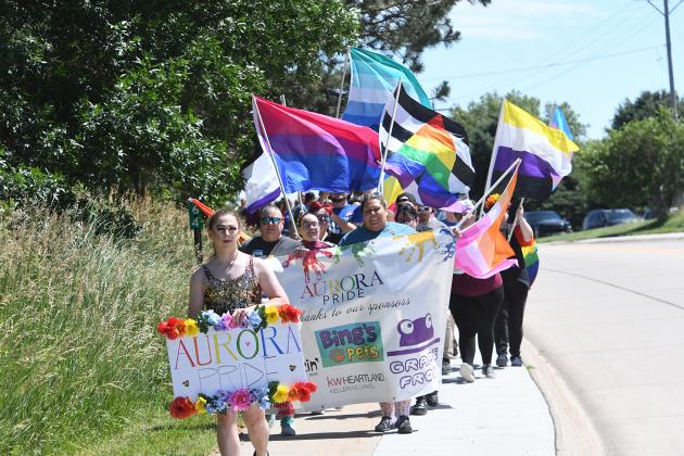 A crowd of 100 strong waved banners and signs while marching along Highway 14 Saturday during Aurora’s second annual Pride March.