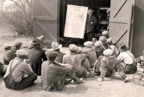An Extension agent meets with a group of rural Nebraskans, discussing how an ignition engine works, in this undated photo. (University Archives and Special Collections)