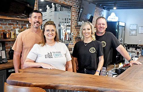 Part of the ownership team behind Hampton's new Loading Chute restaurant stands at the bar of the newly renovated establishment on 3rd Street. From left: Ryan and Tammie Bamesberger and Lisabeth and Grant Dose